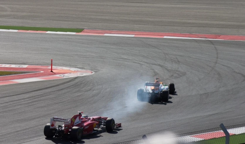 two racing cars driving around an empty track