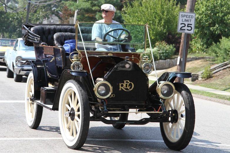 an old timey car on a street with a hat