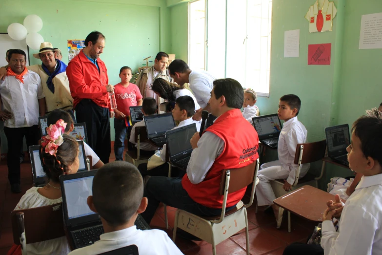 a group of men sitting in front of laptops on desk