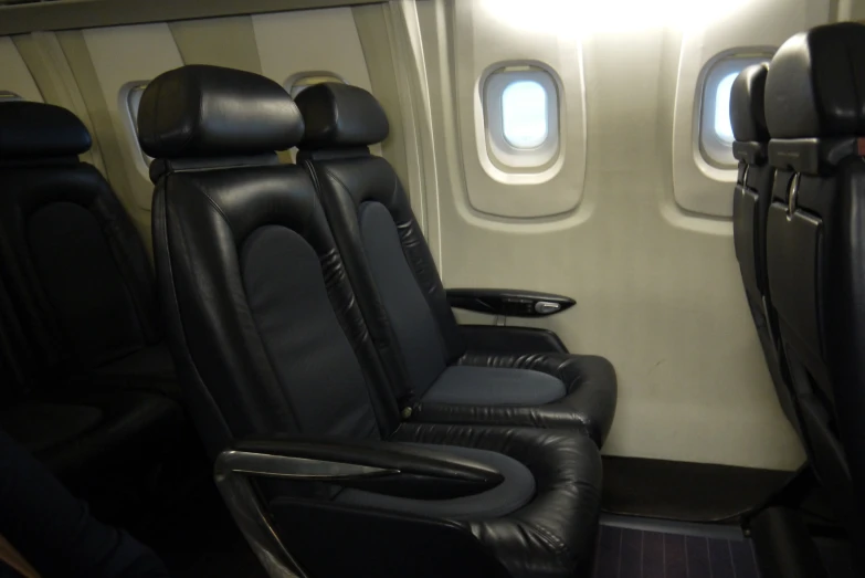 the inside of an airplane with black leather seats