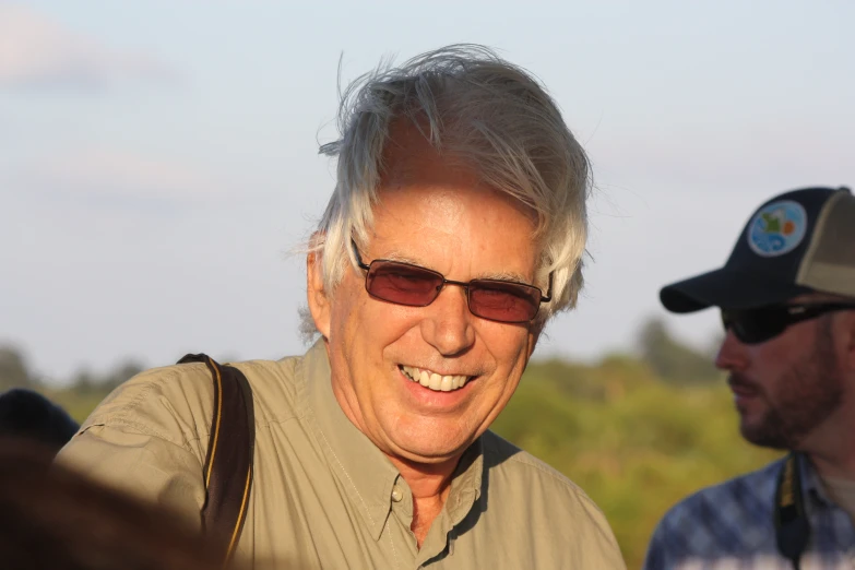 an older man smiling with his hat on