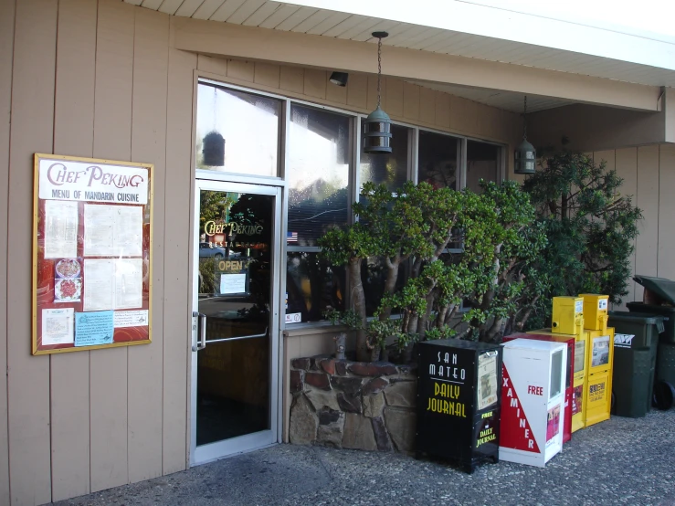 a front door of a pizza joint with boxes of junk