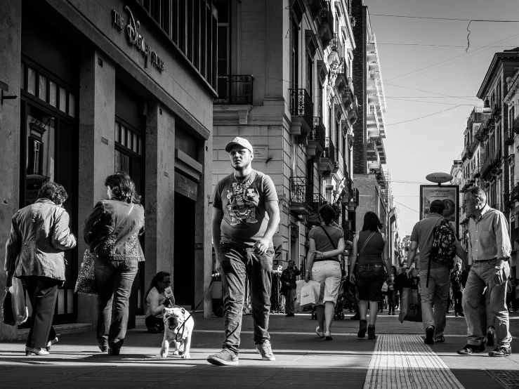 a man in a hat walking on the street in front of a crowd