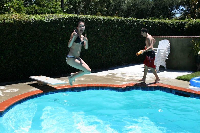 two young s in the pool jumping into the water