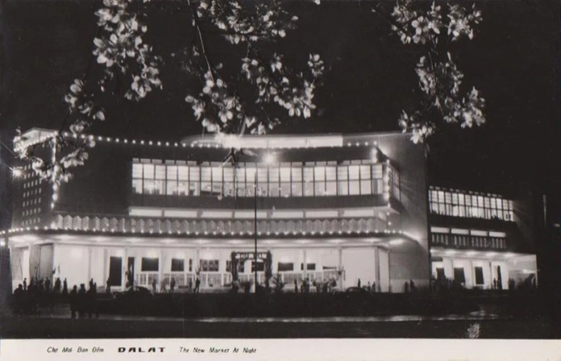 an old pograph of the exterior of a building with christmas lights