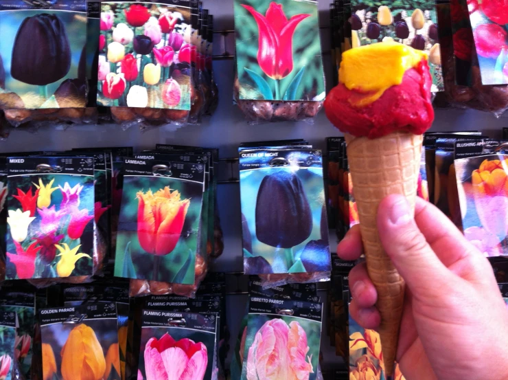 a person holds up an ice cream cone decorated with flowers