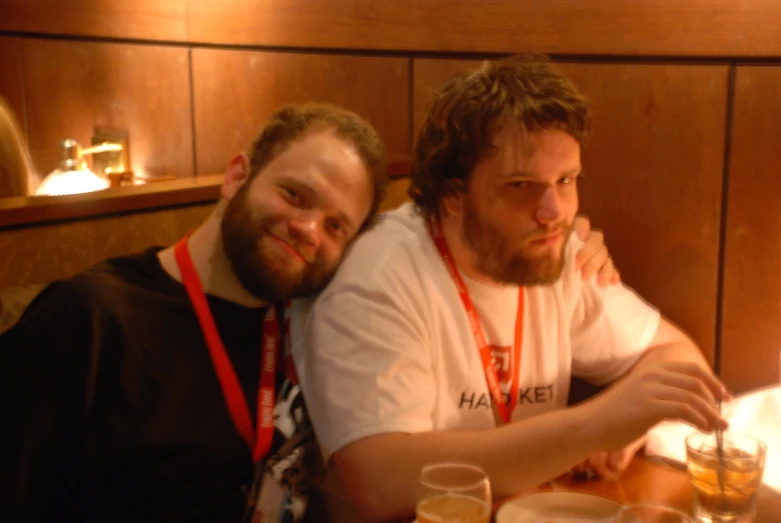 two men sitting next to each other at a table