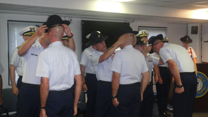 men in service uniforms saluting each other with their hands together