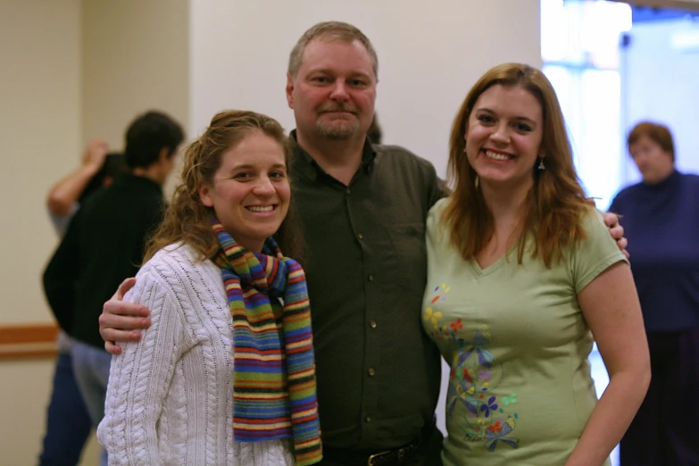 a man and two women smiling in front of a group