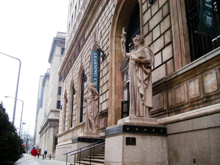 a building with a statue outside and a man holding a flag