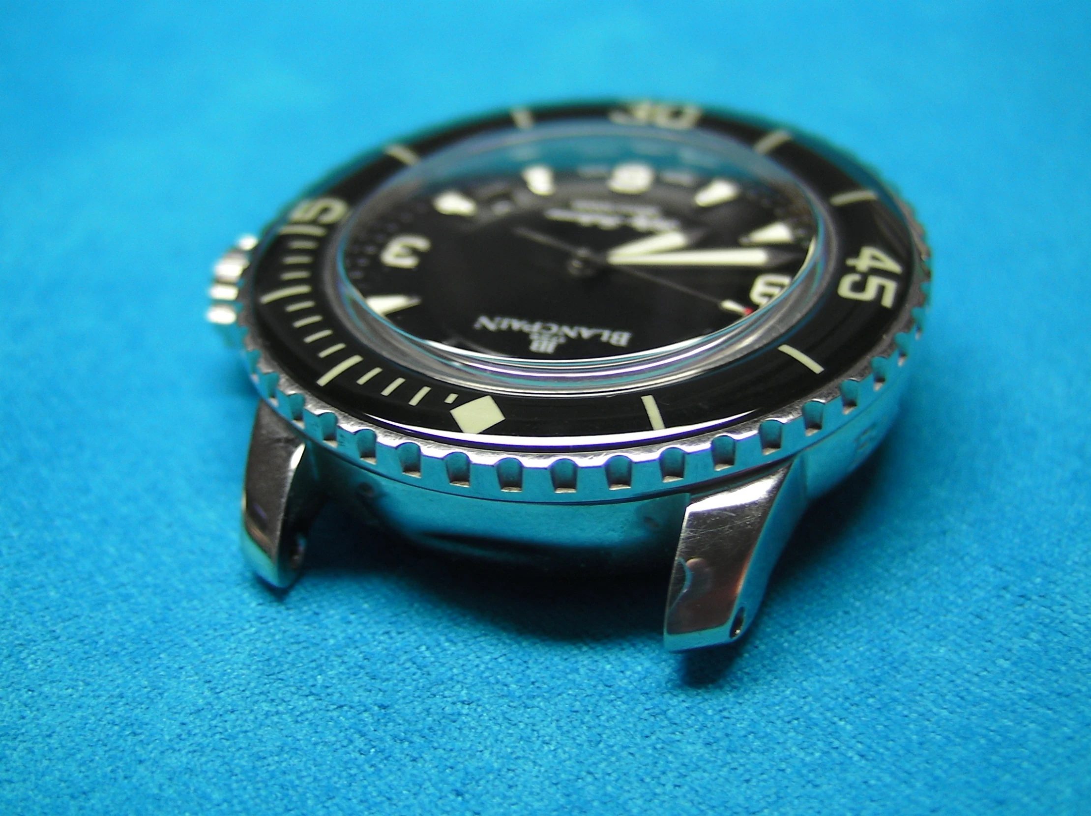 a blue watch sitting on a blue surface