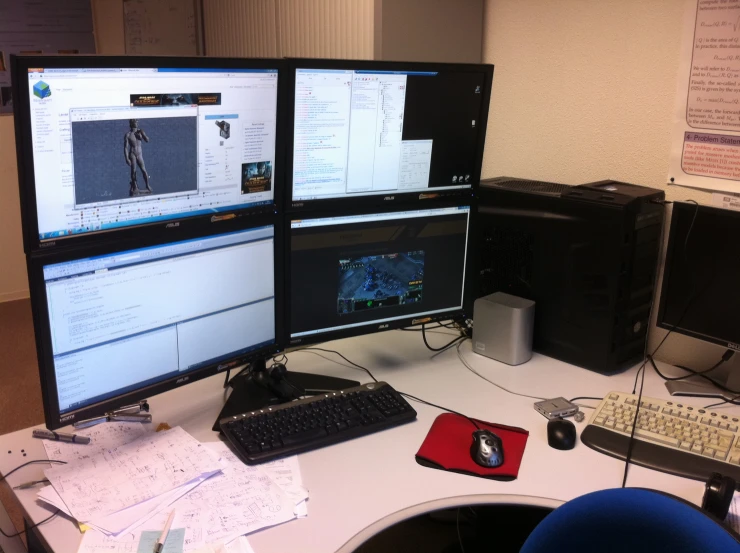 two computer screens with keyboards and a keyboard sitting next to each other