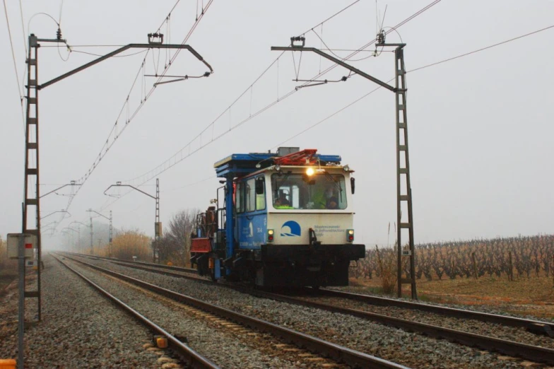 a train on the tracks with power lines above