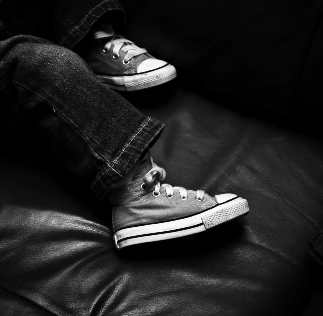 someone has their feet on a leather couch