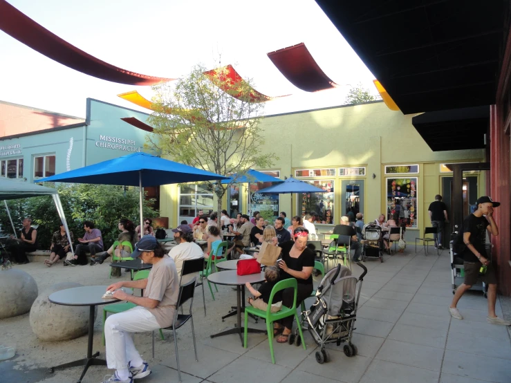 a bunch of people are sitting outside at tables