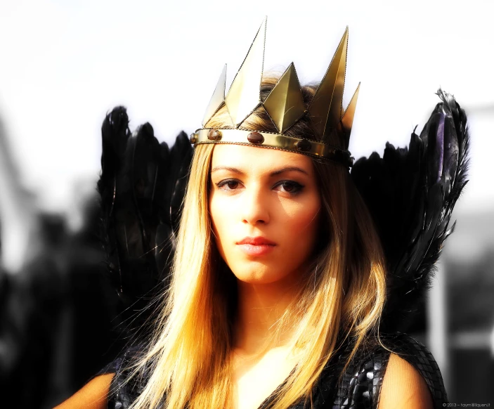 a beautiful young blonde in a tiara with black wings