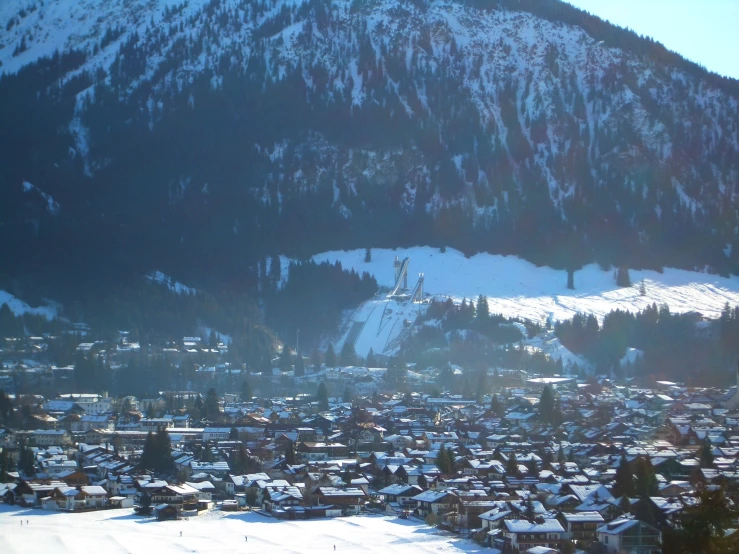 the city in front of the mountain is covered in snow