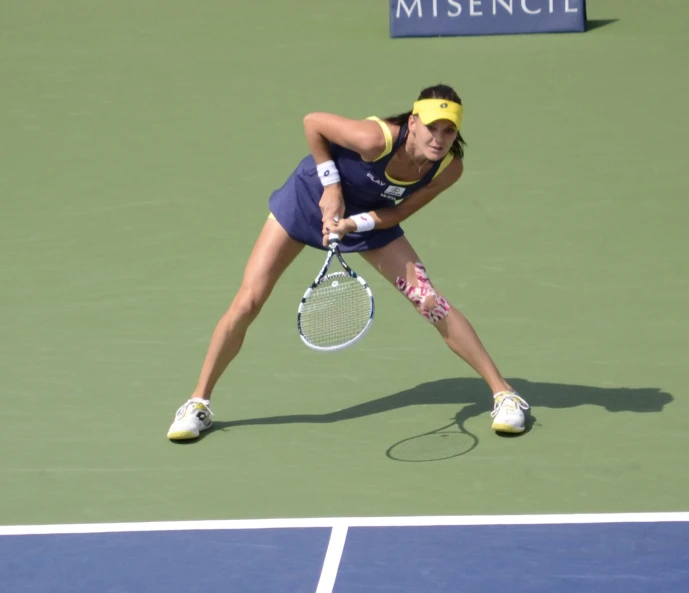 woman wearing blue clothes preparing to hit a tennis ball
