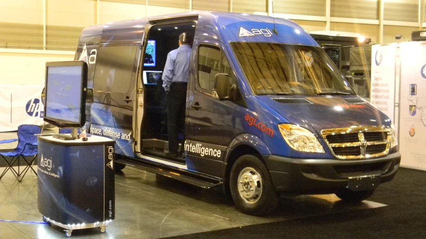 a man is talking into a video screen in the back of a truck