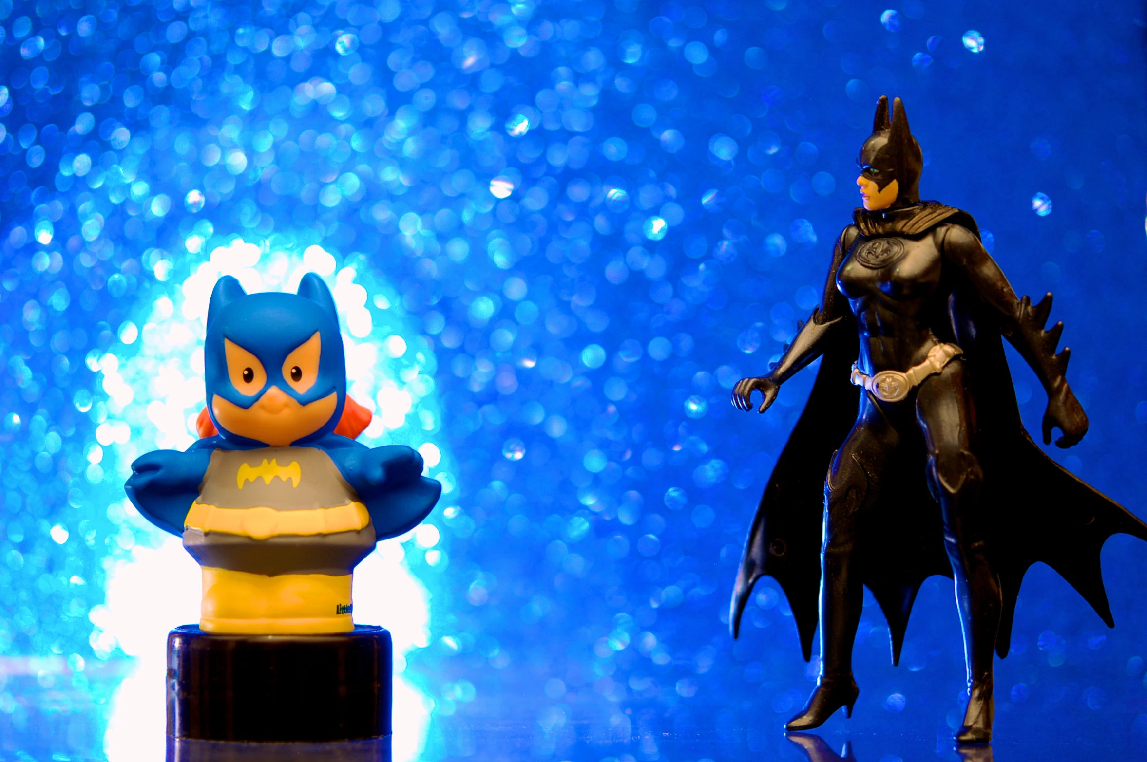 a batman and rubber duck figure posed side by side on a blue background
