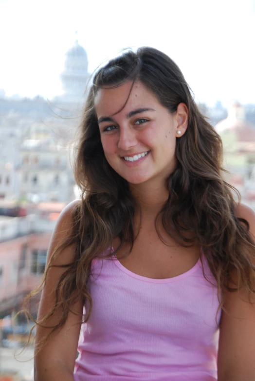 the young woman is standing near a city skyline