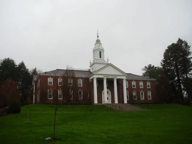 a church with columns and a clock tower on a cloudy day