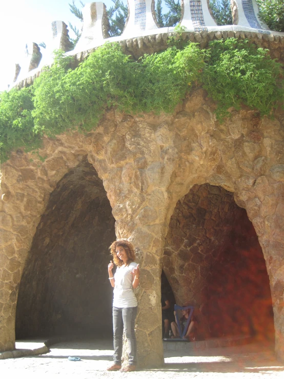 a lady standing under an arch in a rock and stone structure