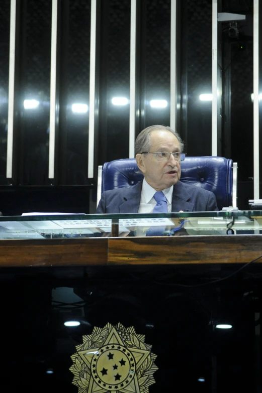 a man wearing a suit sitting at a desk