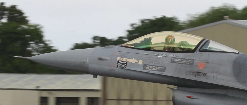 the fighter jet is in front of a building