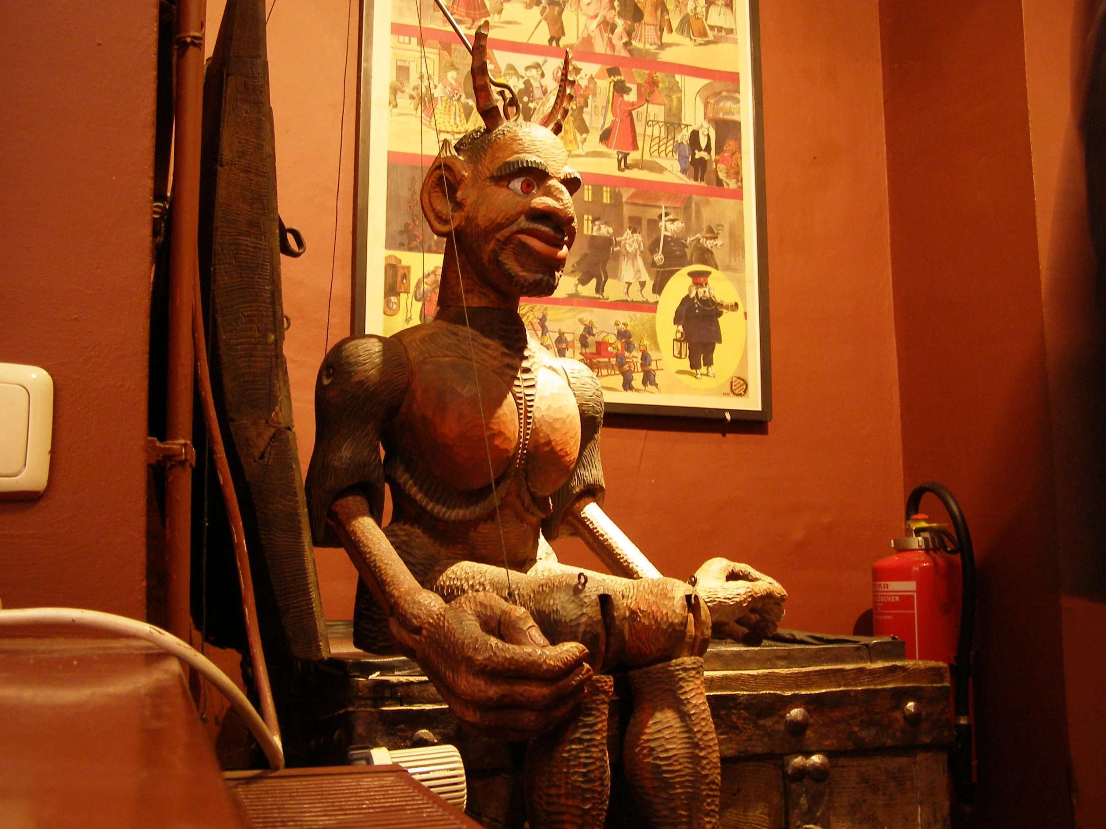 a wooden carved figure sitting on top of a chest