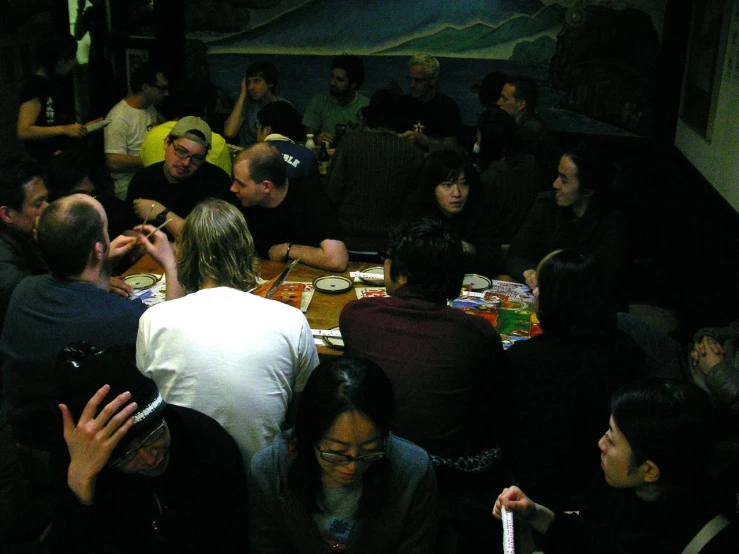a group of people sit at the table with snacks and drinks in front of them