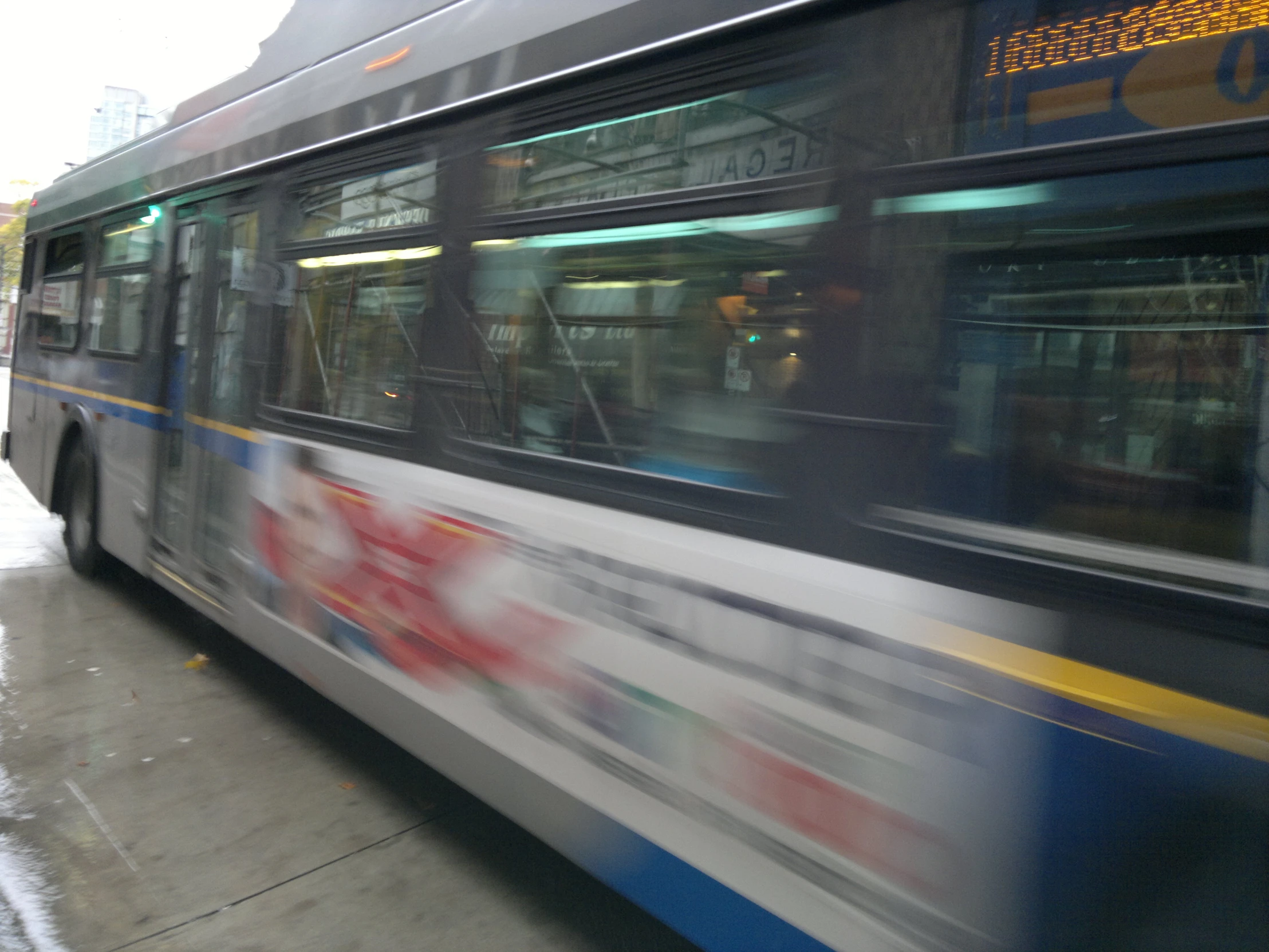 a bus drives down a street near some buildings