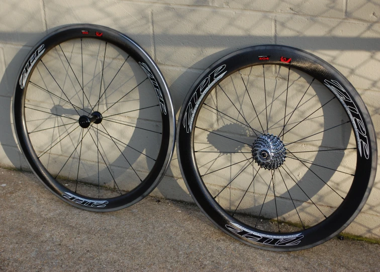 two bicycle wheels are beside each other on the sidewalk