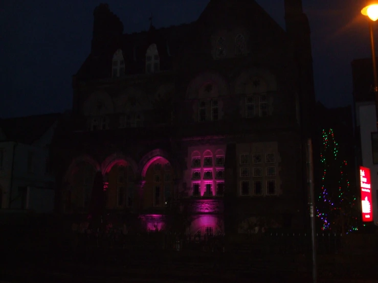 building with purple lights during the night on dark street