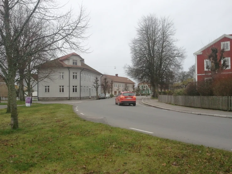 car driving on road in front of residential neighborhood