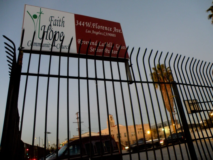 a red van driving next to a fence and sign