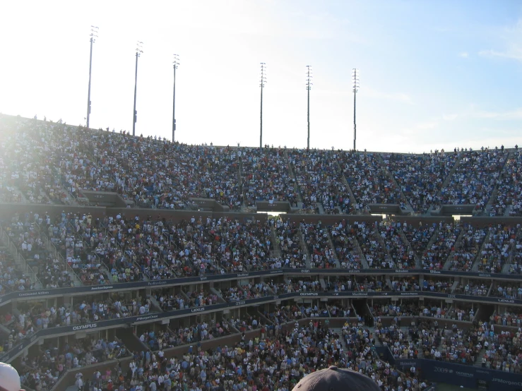 a crowd in a tennis arena filled with people