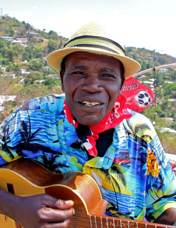 a man playing an acoustic guitar wearing a hat