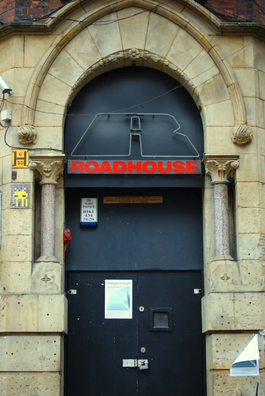 an old building has a black door and sign on the front