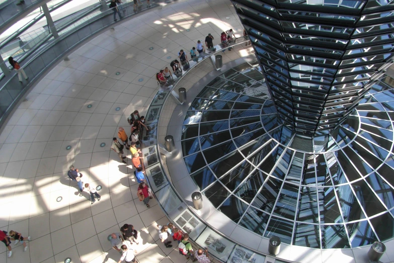 the view of people walking around looking at the glass roof