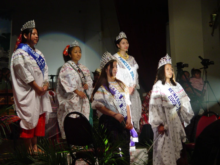 a number of women on a stage wearing crowns