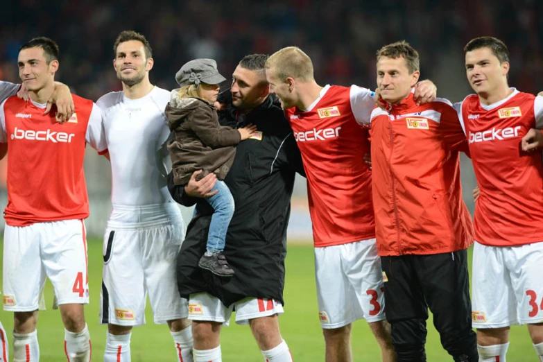 a man hugging a child in front of a group of people