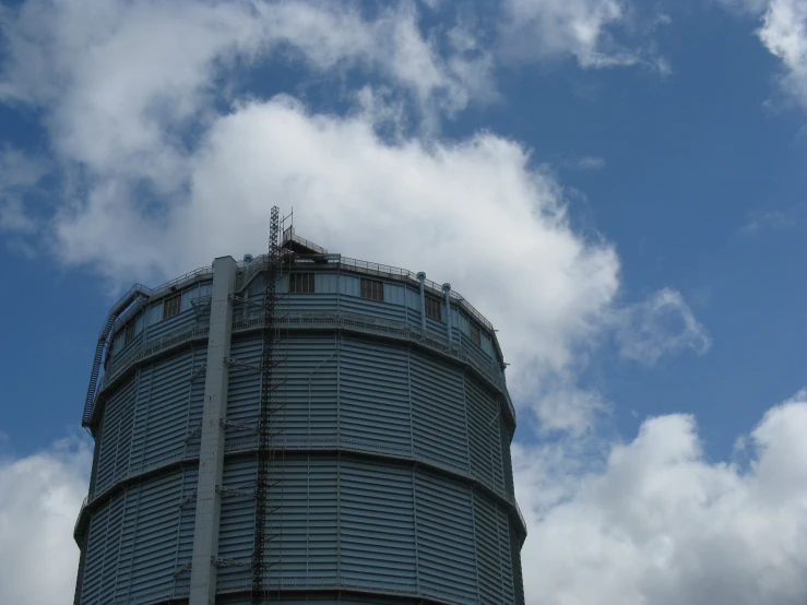 a large gray building is under a cloudy blue sky