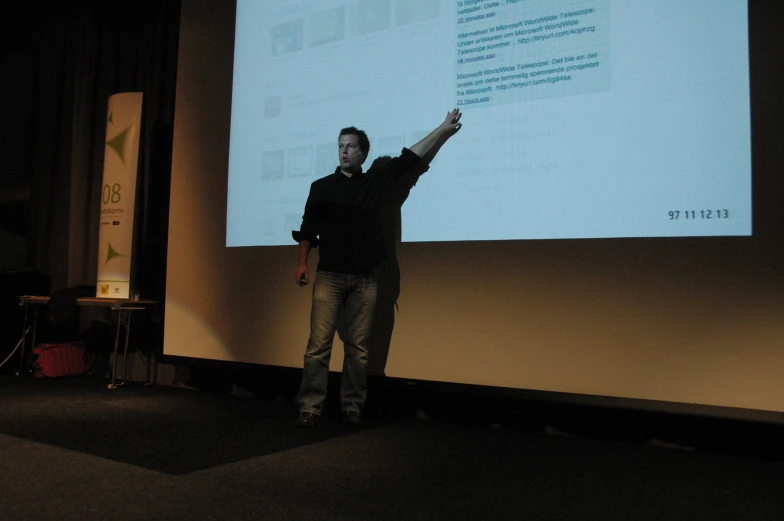 man standing next to a projection screen showing information