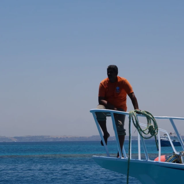 the man is hanging on the railing near a boat