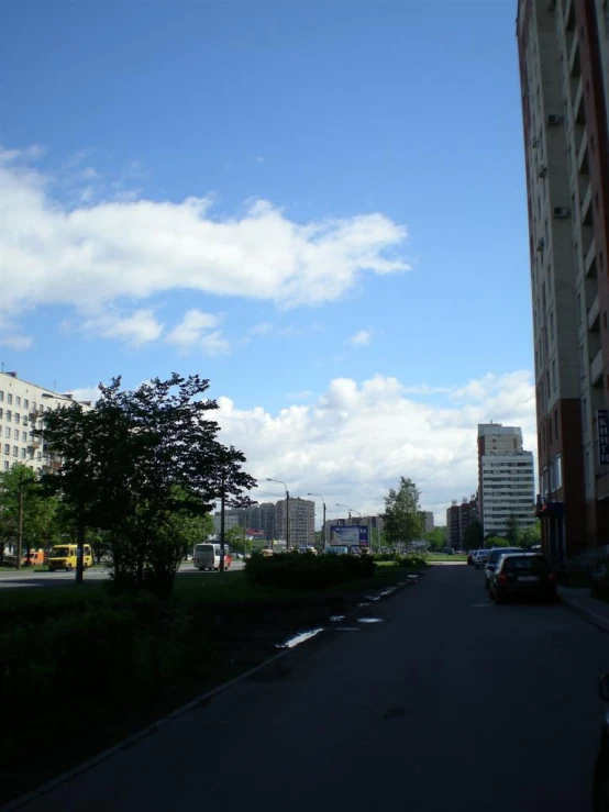 looking down an empty street with cars parked along the road