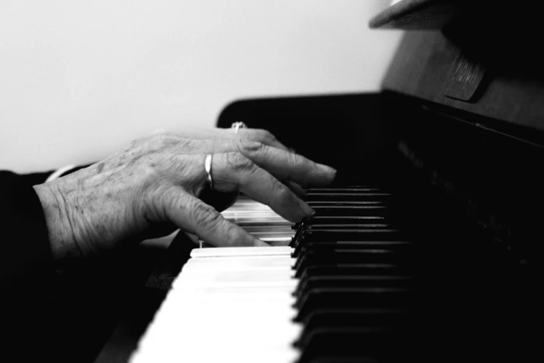 hands on the piano keyboard are touching it with their fingers