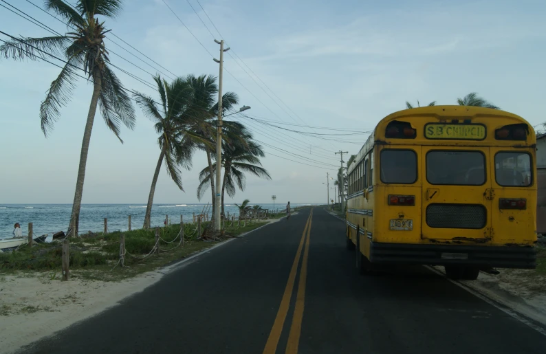 a yellow bus is traveling down the street