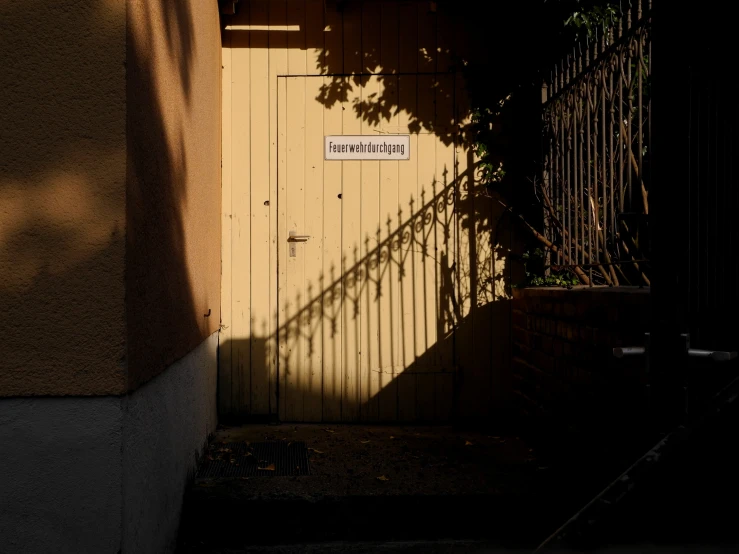 an exterior gate with the shadow of an umbrella over it