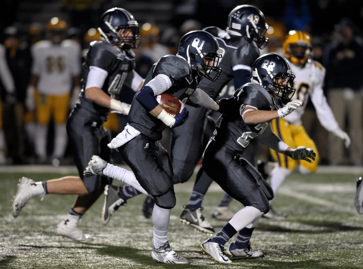 a group of football players running through the field